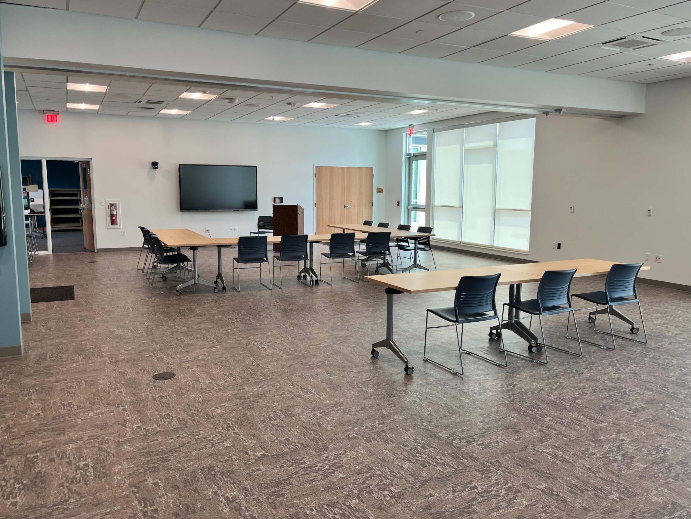 Full Community Room - a large well lit space with tables and chairs