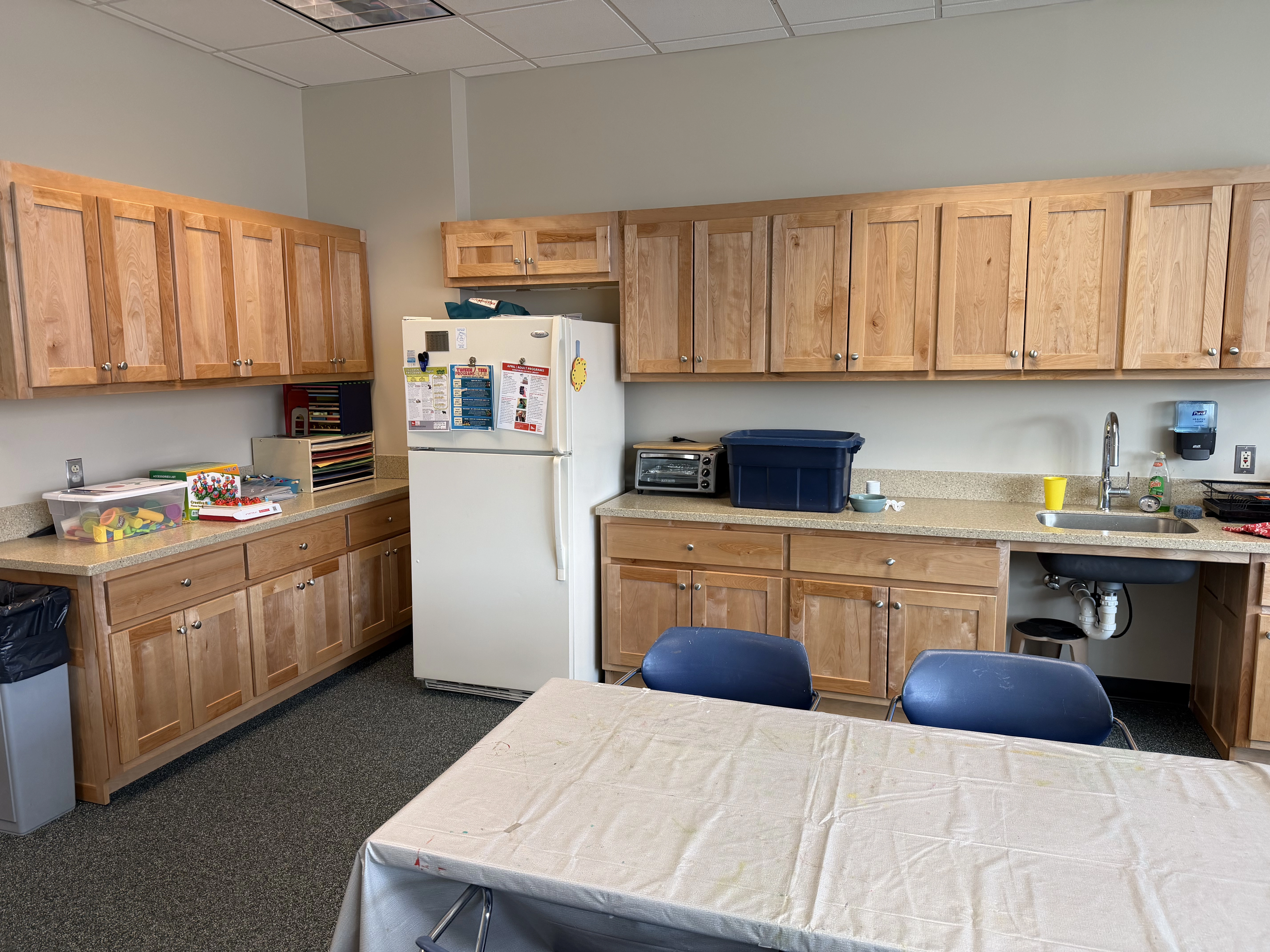 A view of the kitchen in the room featuring wooden cabinets and a refrigerator