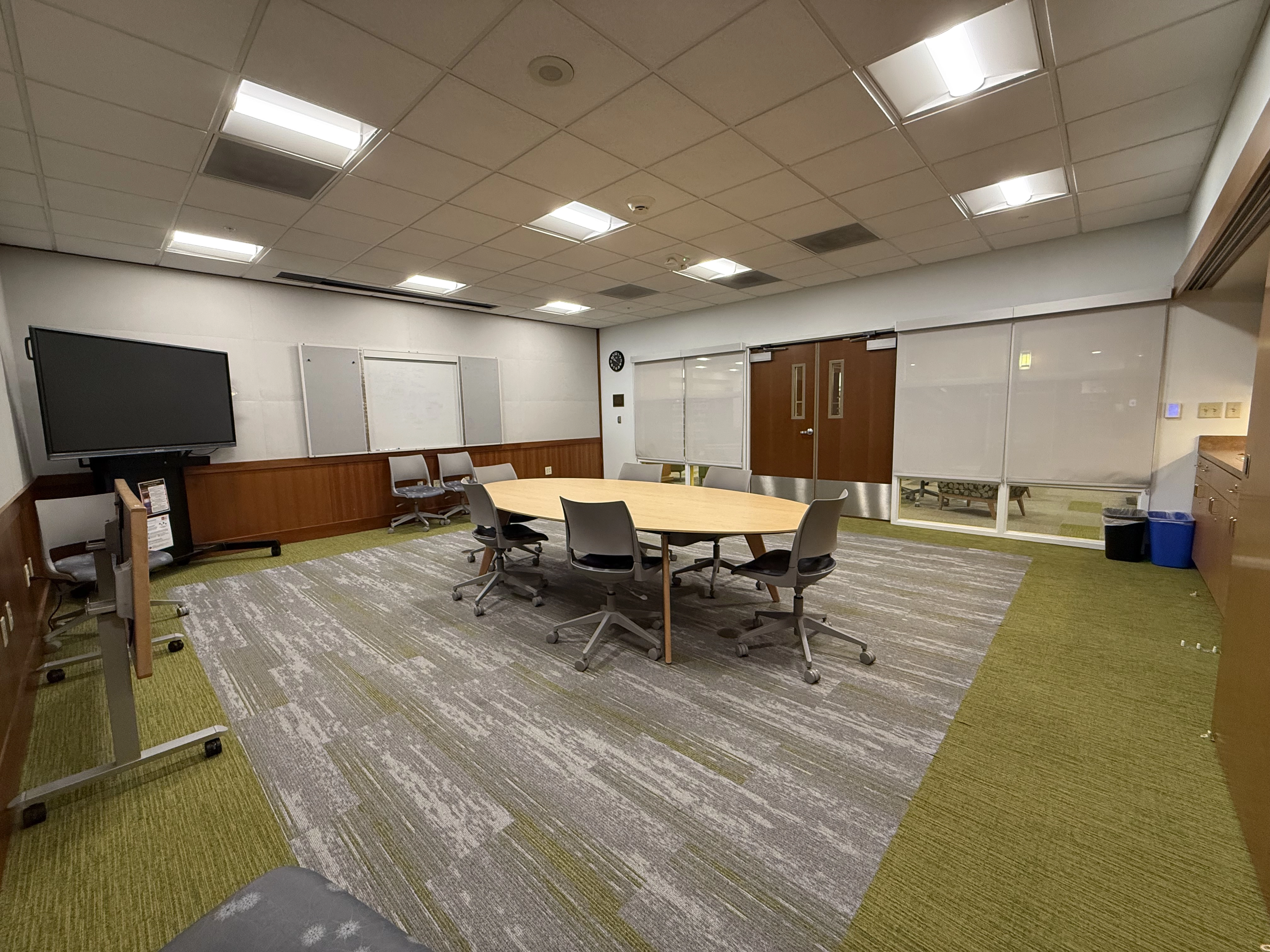 a view of the Trust room from the far leftt hand corner facing the door way showing a large oval table and chairs