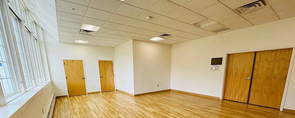 A view of a brightly lit space with a wall of windows on the left hand side