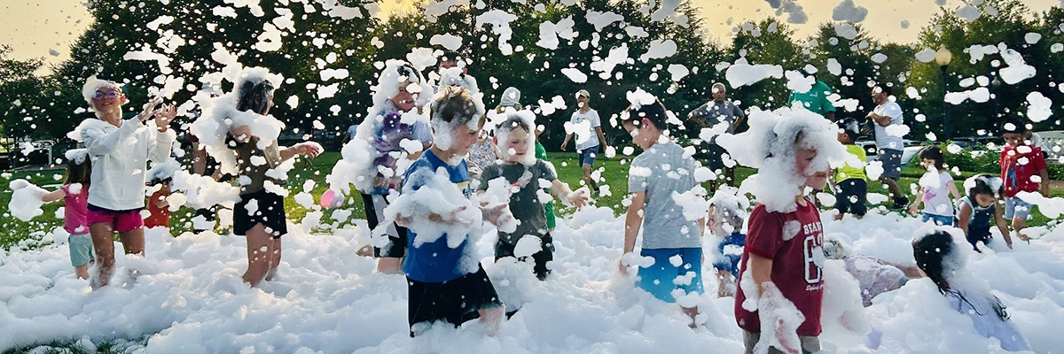 a group of children frollic in bubbles