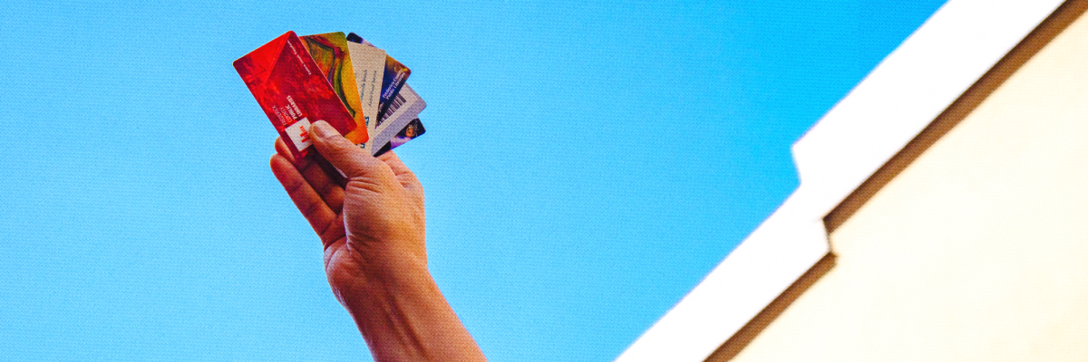 A photo of a hand holding a few different FCPL Library Cards
