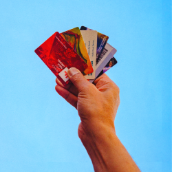 A photo of a hand holding a few different FCPL Library Cards