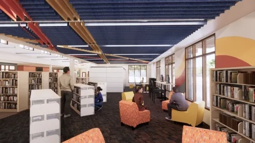 Another view of a brightly lit, colorful bookstacks with customers enjoying the space