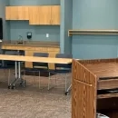 Meeting Room A showing a brightly lit space with kitchen area, tables, chairs and a podium