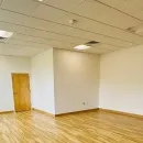 A view of a brightly lit space with a wall of windows on the left hand side